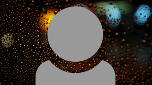 A grey person icon showing just head and shoulders with a blurred image of lights shining through a glass pane with waterdrops background.