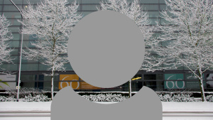 A grey person icon showing just head and shoulders with a cold snowy University building background.