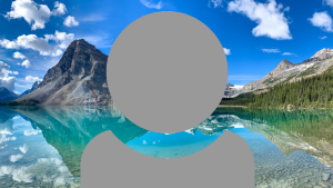 A grey person icon showing just head and shoulders with a mountain range with reflective blue water background.